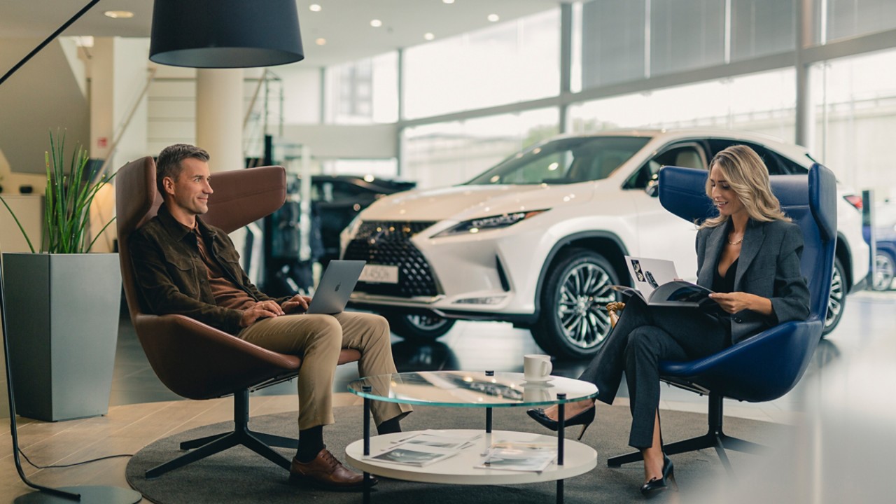 A man and woman sat in a Lexus retailer