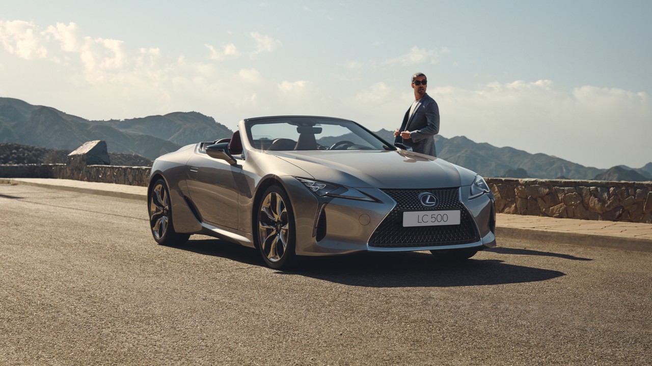 A man standing next to a Lexus LC Convertible