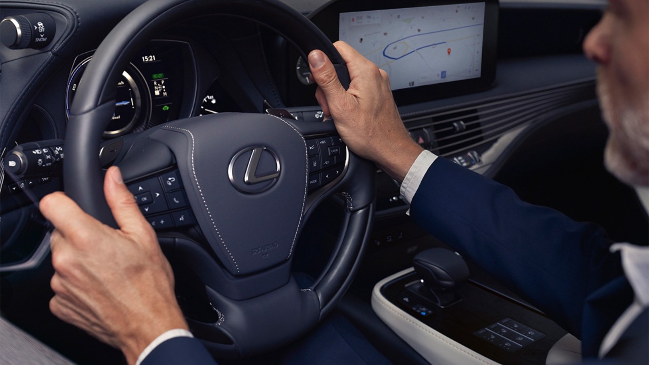 A man with his hands on the Lexus LS steering wheel