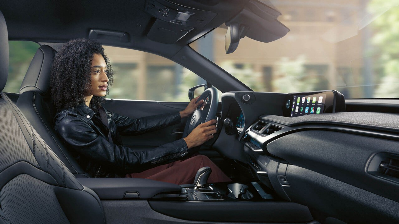A woman driving a Lexus UX 300e