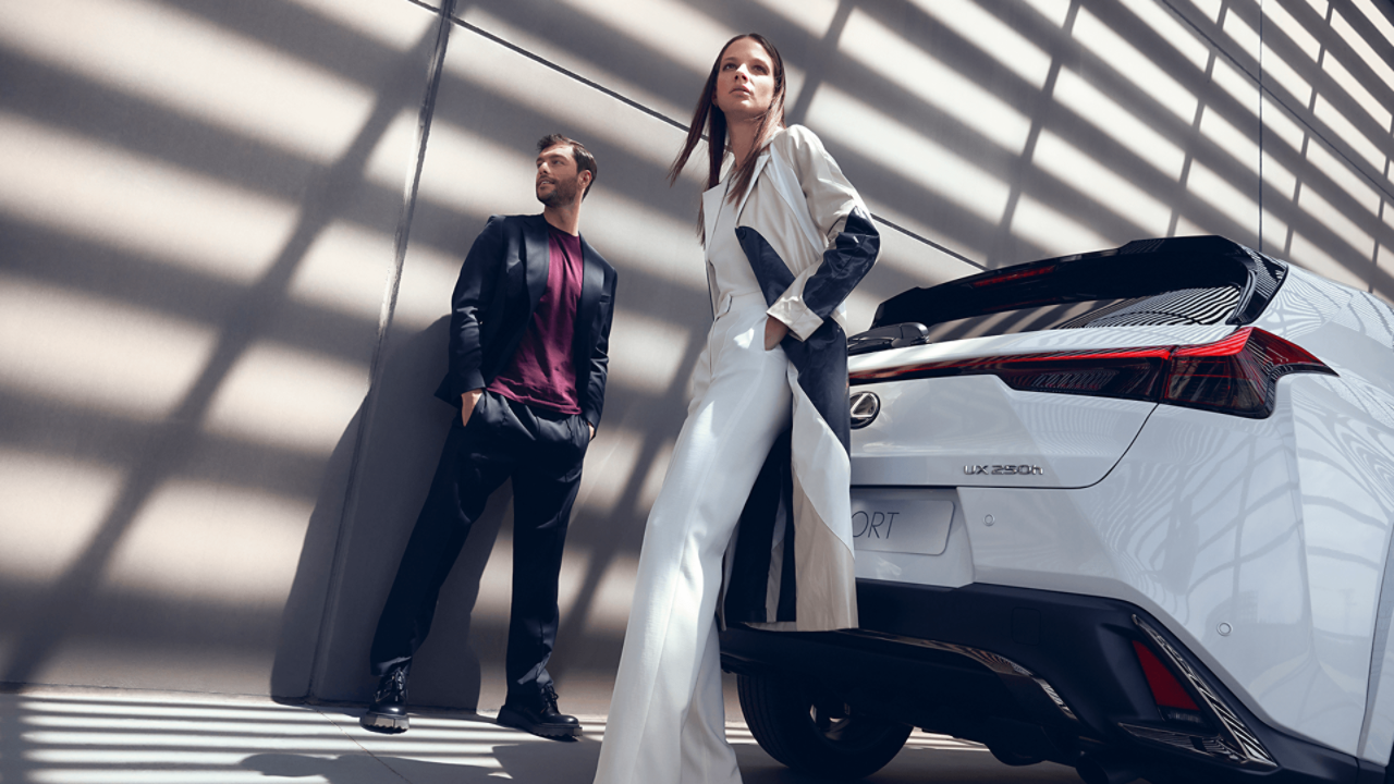  A man and women stood next to a Lexus UX F Sport
