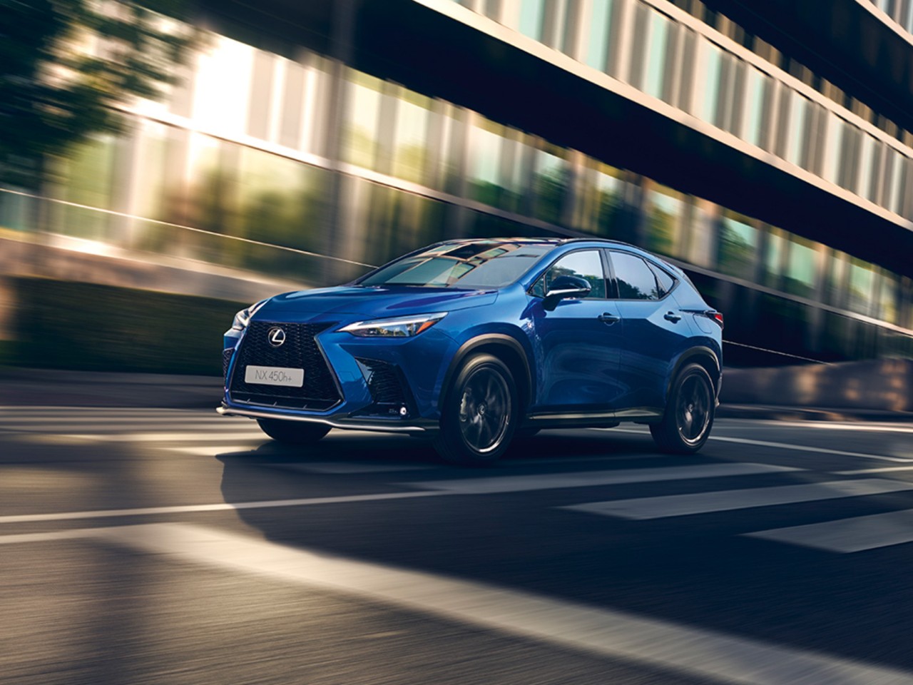 Lexus NX 450h+ driving in a city location 